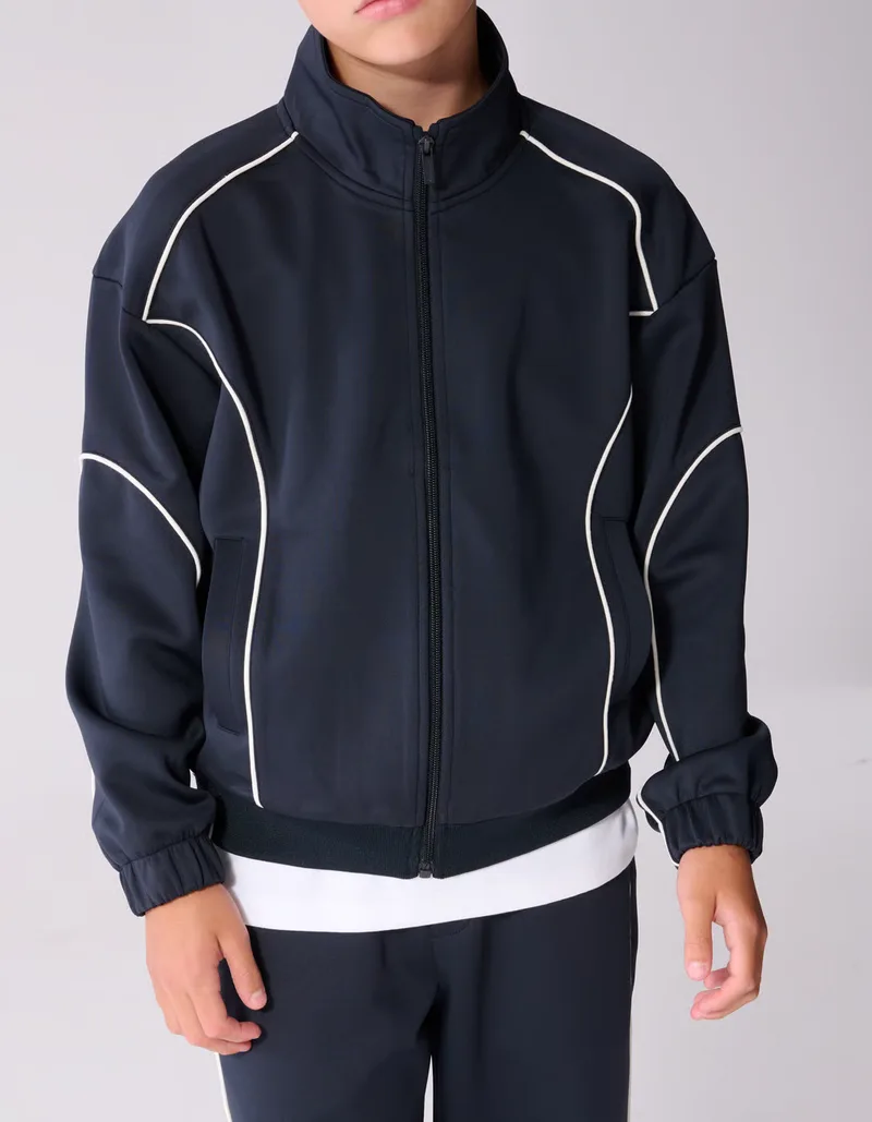 A navy track jacket with white piping worn by a person, the frame cropped above the mouth